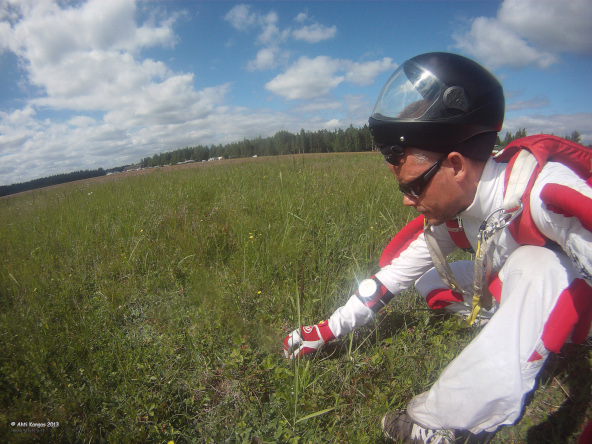 Skydiving instructor eating wild strawberries on drop zone. Vesivehmaa 2013.